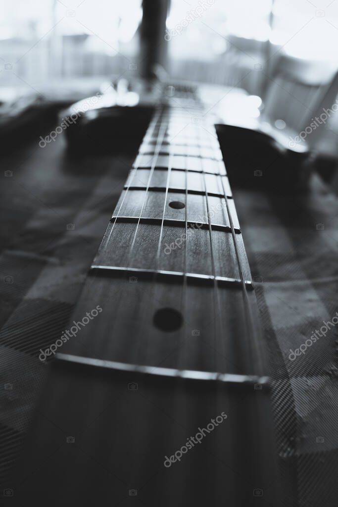 electric guitar frets and strings with selective focus and shallow depth of field