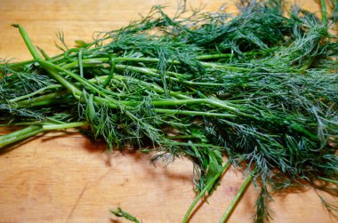 Tahta kesme tahtasının üzerinde dereotu demeti