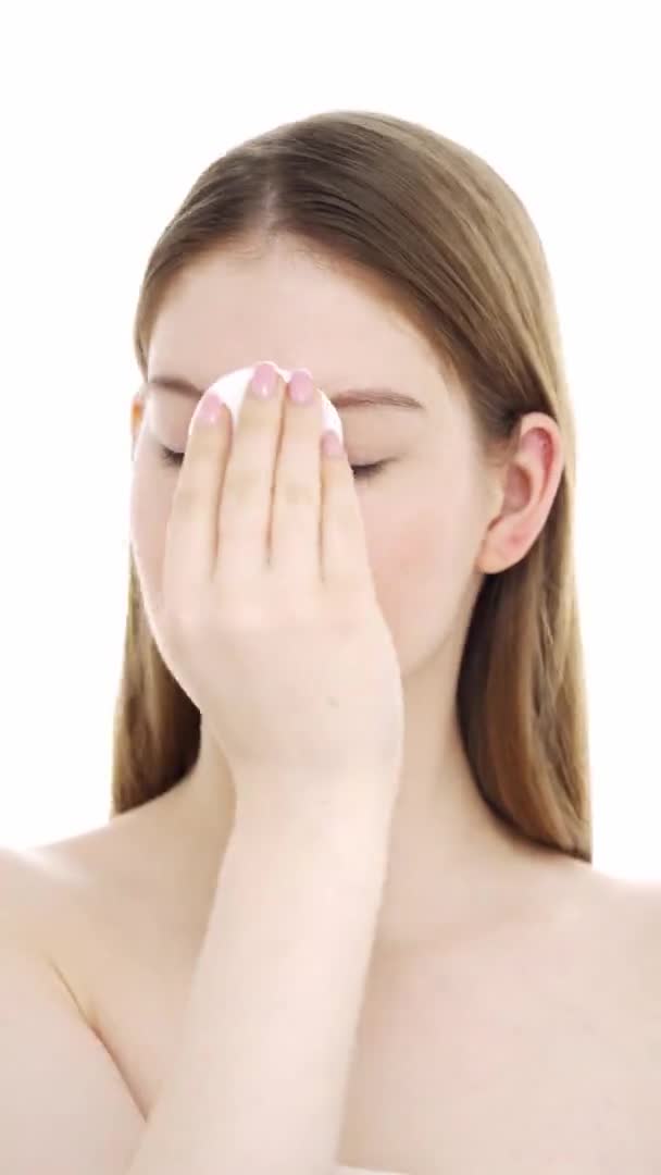 Young woman removes makeup with cotton pad. Vertical orientation video — Stock Video