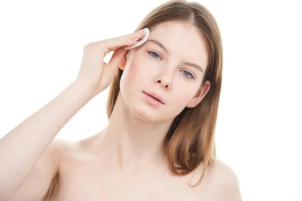 Ung kvinna med perfekt hud tar bort makeup från ansiktet med bomullspad. — Stockfoto