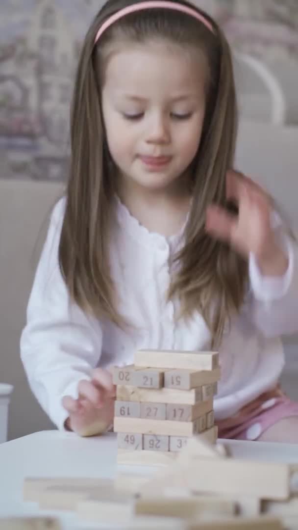 Cute Curious Little Girl Builds Tower Wooden Blocks Concept Board — Stock Video