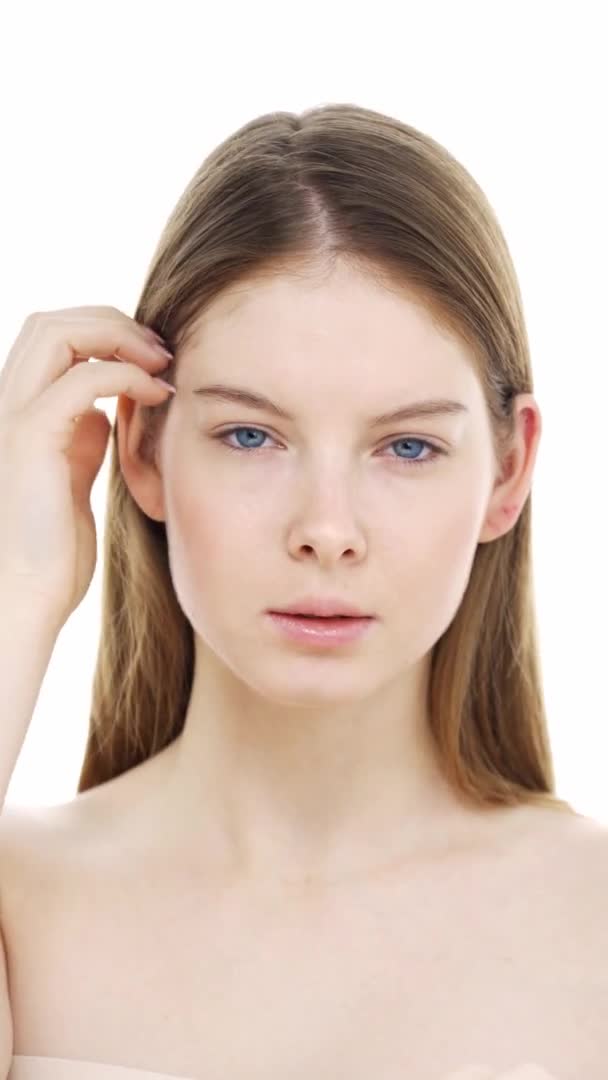Jeune femme vérifie l'état de sa peau, faire un massage facial. — Video