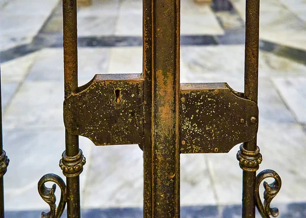 Eski ve paslı bir ızgaranın kilidi, kilisenin içinde, en değerli hazinelerini koruyor..