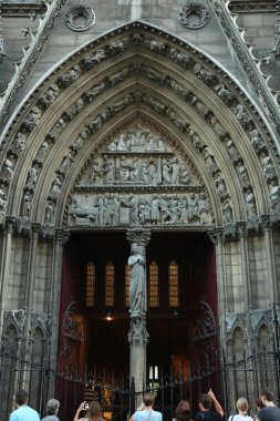 Tourists near the side entrance is an arch with sculptures in Notre Dame Cathedral. Paris. 01.10.2011