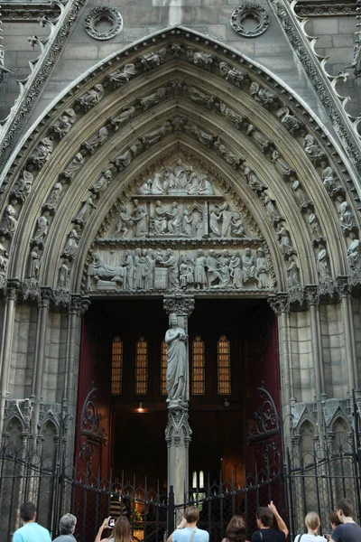 Tourists near the side entrance is an arch with sculptures in Notre Dame Cathedral. Paris. 01.10.2011