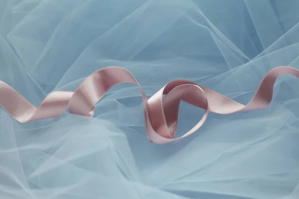 Abstract curly silk ribbon on tulle fabric. Pastel colors