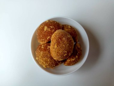 Gula jawa ya da java şekeri ya da kırmızı şeker ya da palmiye şekeri, yarım top şeklinde, beyaz kasenin içinde. Beyaz arkaplanda izole edilmiş