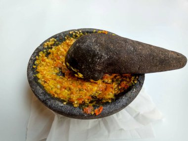 Endonezya 'dan gelen Sambal ya da geleneksel biber sosu. Taş havan ve tokmak kullanılarak yeni yapılmış, beyaz arka planda izole edilmiş.