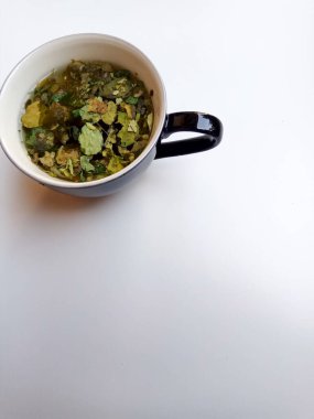 Moringa oleifera bitkisel çay gibi, şeffaf cam içinde, beyaz arka planda izole.