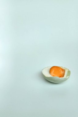 Yarım tuzlu yumurta, beyaz arka planda izole edilmiş.