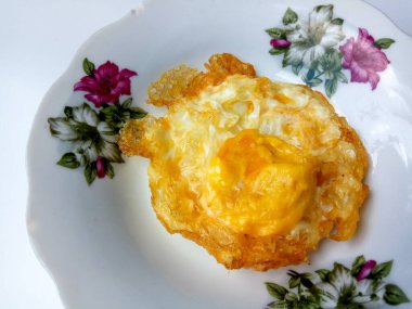 Kızarmış yumurta ya da fazla pişmiş güneşte pişmiş, beyaz bir tabakta beyaz pirinçle servis edilmiş, beyaz arka planda izole edilmiş.. 