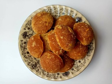 Gula jawa ya da java şekeri ya da kırmızı şeker ya da palmiye şekeri, yarım top şeklinde, beyaz kasenin içinde. Beyaz arkaplanda izole edilmiş