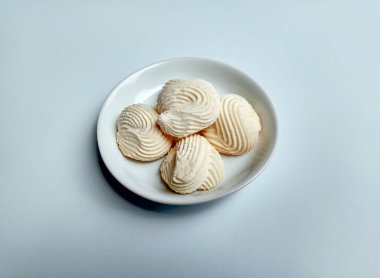 Spritz kurabiyeleri, ya da muhallebi kurabiyeleri ya da Endonezya dilinde roti semprit. Midye kabuğu şeklinde kurabiyeler. Beyaz küçük tabağın içine yerleştirilmiş.