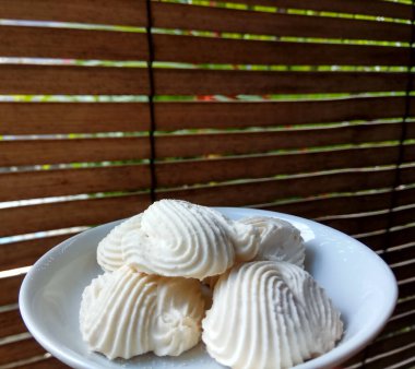 Spritz kurabiyeleri, ya da muhallebi kurabiyeleri ya da Endonezya dilinde roti semprit. Midye kabuğu şeklinde kurabiyeler. Beyaz küçük tabağın içine yerleştirilmiş.