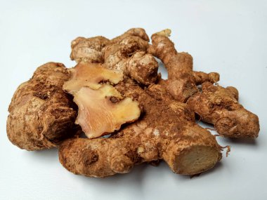 Zingiber officinale rhizome ya da toprak kaplı zencefil kökü, küçük beyaz tabakta. Beyaz arkaplanda izole edilmiş.