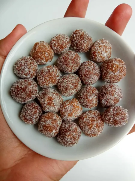 Demirhindi şekeri, beyaz küçük tabağın içine yerleştirilmiş. Demirhindi ezmesinden yapılmış ve şekerle kaplanmış tatlı ve ekşi şeker..