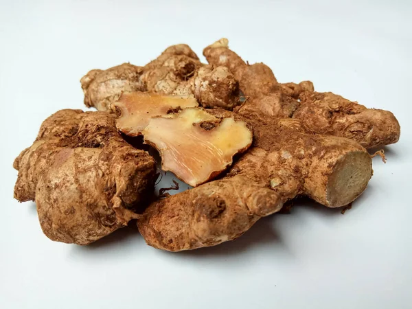 Zingiber officinale rhizome ya da toprak kaplı zencefil kökü, küçük beyaz tabakta. Beyaz arkaplanda izole edilmiş.
