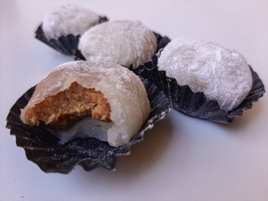 Moaci ya da Mochi beyaz unla kaplı, Endonezya versiyonu. Fıstık ezmesiyle doldurulmuş pirinç keki. Beyaz arkaplanda izole edilmiş
