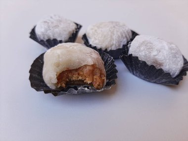 Moaci ya da Mochi beyaz unla kaplı, Endonezya versiyonu. Fıstık ezmesiyle doldurulmuş pirinç keki. Beyaz arkaplanda izole edilmiş