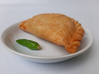 Pastel, tavuk eti ve karışık sebzelerle dolu bir hamur işi, sonra da bol yağda kızartılmış. Endonezya 'dan atıştırmalık. Beyaz tabakta. Beyaz arkaplanda izole edilmiş.