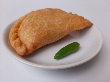 Pastel, tavuk eti ve karışık sebzelerle dolu bir hamur işi, sonra da bol yağda kızartılmış. Endonezya 'dan atıştırmalık. Beyaz tabakta. Beyaz arkaplanda izole edilmiş.