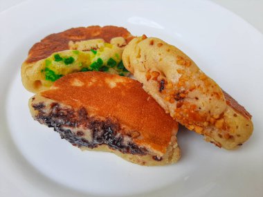 Pukis, çeşitli malzemelerle geleneksel Endonezya krepi. Beyaz tabakta. Beyaz arkaplanda izole edilmiş.