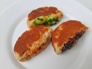 Pukis, çeşitli malzemelerle geleneksel Endonezya krepi. Beyaz tabakta. Beyaz arkaplanda izole edilmiş.