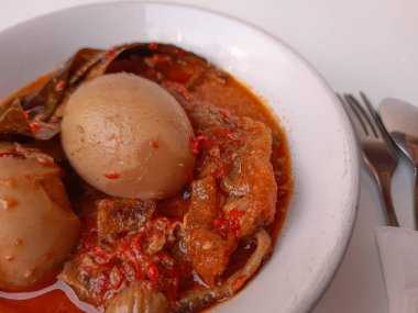 Endonezya yemeği, sambal goreng ati olarak adlandırılır. Tavuk taşlığı, biber, haşlanmış yumurta, hindistan cevizi sütü ve krupuk kulit (inek derisinin yumuşak içi) içerir. Bayram için özel yemek. Seçici odak.