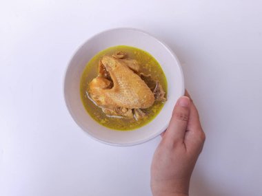 Hindistancevizi sütüyle öğütülmüş tavuk. Opor Ayam adlı Endonezya yemeği. Bayram için imza tabağı getirdim. Beyaz arkaplanda izole edilmiş.