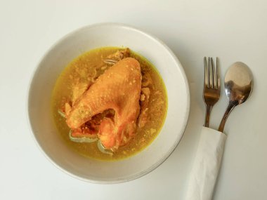 Hindistancevizi sütüyle öğütülmüş tavuk. Opor Ayam adlı Endonezya yemeği. Bayram için imza tabağı getirdim. Beyaz arkaplanda izole edilmiş.