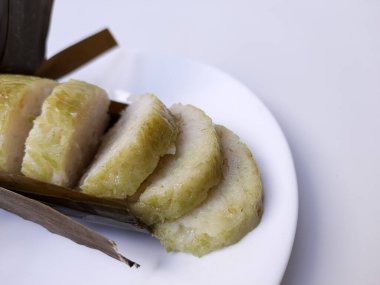 Lontong, muz yaprağına sarılmış silindir şeklinde sıkıştırılmış pirinç kekinden yapılmış bir Endonezya yemeğidir. Dilimlere ayırın. Beyaz arkaplanda izole edilmiş.