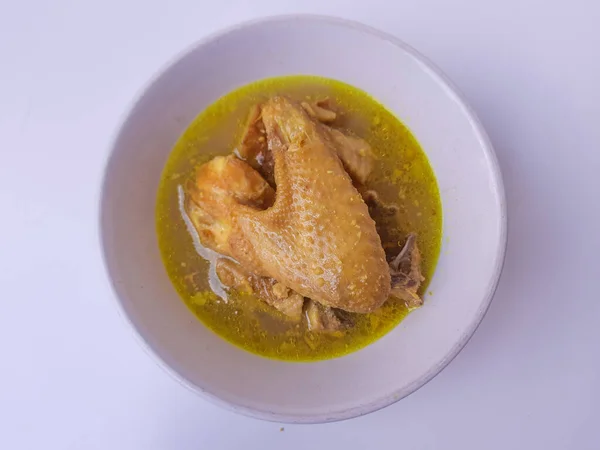 Chicken braised in coconut milk with turmeric. Indonesian food called Opor Ayam. Signature dish for Eid Holiday. Isolated in white background.