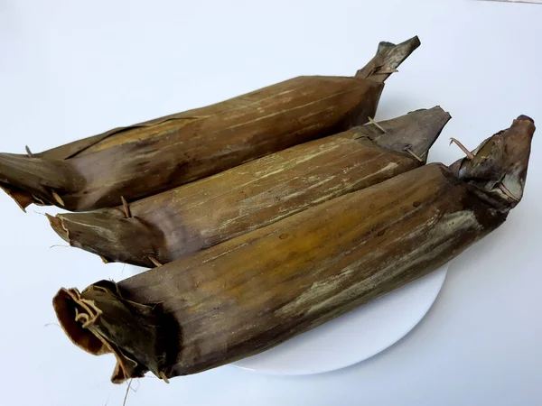 龙通是印度尼西亚的一道菜 由压缩米糕制成 其形式是一个圆筒 包裹在香蕉叶中 切成片 与白色背景隔离 — 图库照片