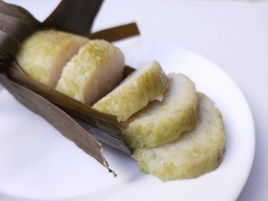 Lontong, muz yaprağına sarılmış silindir şeklinde sıkıştırılmış pirinç kekinden yapılmış bir Endonezya yemeğidir. Dilimlere ayırın. Beyaz arkaplanda izole edilmiş.