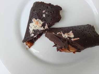 Dadar Gulung Pisang Cokelat, ya da muz ve çikolata soslu rulo tatlı omlet. Endonezya 'dan geleneksel atıştırmalıklar. Beyaz arka planda izole edilmiş. Üst görünüm veya düz uzanma