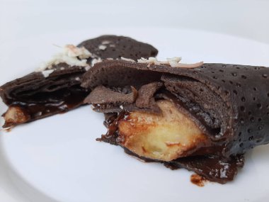Dadar Gulung Pisang Cokelat, ya da muz ve çikolata soslu rulo tatlı omlet. Endonezya 'dan geleneksel atıştırmalıklar. Beyaz arka planda izole edilmiş. Üst görünüm veya düz uzanma