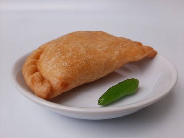 Pastel, tavuk eti ve karışık sebzelerle dolu bir hamur işi, sonra da bol yağda kızartılmış. Endonezya 'dan atıştırmalık. Beyaz tabakta. Beyaz arkaplanda izole edilmiş.