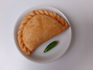 Pastel, tavuk eti ve karışık sebzelerle dolu bir hamur işi, sonra da bol yağda kızartılmış. Endonezya 'dan atıştırmalık. Beyaz tabakta. Beyaz arkaplanda izole edilmiş.