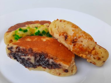 Pukis, çeşitli malzemelerle geleneksel Endonezya krepi. Beyaz tabakta. Beyaz arkaplanda izole edilmiş.