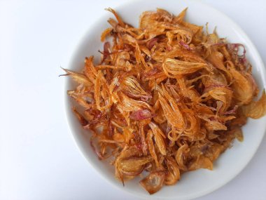 Küçük bir kasede bir yığın kızarmış soğan. Beyaz arkaplanda izole edilmiş.