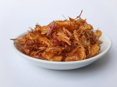 Küçük bir kasede bir yığın kızarmış soğan. Beyaz arkaplanda izole edilmiş.