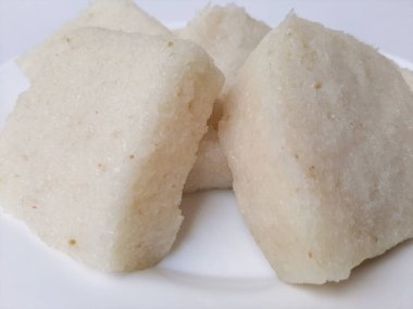 Jadah ketan, Endonezya 'dan geleneksel bir aperatif. Yapışkan pirinç ve rendelenmiş hindistan cevizinden yapılmış. Genellikle çay saatinde atıştırmalık olarak servis edilir. Beyaz bir plaka üzerinde, beyaz arka planda izole edilmiş.