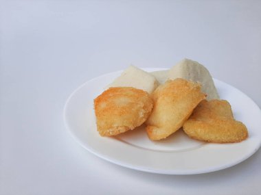 Jadah ketan, Endonezya 'dan geleneksel bir aperatif. Yapışkan pirinç ve rendelenmiş hindistan cevizinden yapılmış. Kızarmadan önceki ve sonraki karşılaştırma. Beyaz bir plaka üzerinde, beyaz arka planda izole edilmiş.