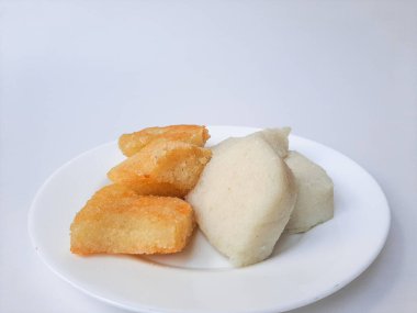 Jadah ketan, Endonezya 'dan geleneksel bir aperatif. Yapışkan pirinç ve rendelenmiş hindistan cevizinden yapılmış. Genellikle çay saatinde atıştırmalık olarak servis edilir. Beyaz bir plaka üzerinde, beyaz arka planda izole edilmiş.