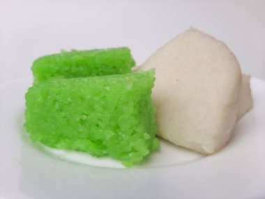 Jadah ketan (beyaz) ve Vak ketan (yeşil), Endonezya 'dan iki geleneksel atıştırmalık. Yapışkan pirinçten yapılmış. Beyaz bir plaka üzerinde, beyaz arka planda izole edilmiş.