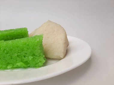 Jadah ketan (beyaz) ve Vak ketan (yeşil), Endonezya 'dan iki geleneksel atıştırmalık. Yapışkan pirinçten yapılmış. Beyaz bir plaka üzerinde, beyaz arka planda izole edilmiş.