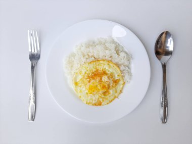 Kızarmış yumurta ya da fazla pişmiş güneşte pişmiş, beyaz bir tabakta beyaz pilav ile servis edilmiş, beyaz arka planda izole edilmiş. Düz ya da üst görünüm ya da genel görünüm