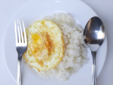 Kızarmış yumurta ya da fazla pişmiş güneşte pişmiş, beyaz bir tabakta beyaz pilav ile servis edilmiş, beyaz arka planda izole edilmiş. Düz ya da üst görünüm ya da genel görünüm