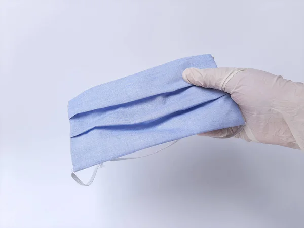Ένα Χέρι Λευκό Λαστιχένιο Γάντι Που Κρατάει Μπλε Μάσκα Απομονωμένα — Φωτογραφία Αρχείου