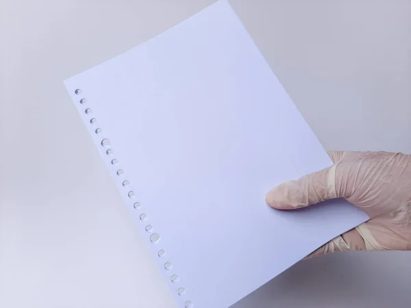 一只戴白色乳胶手套的手拿着一些空白的白纸 隔离在白色的背景上 — 图库照片